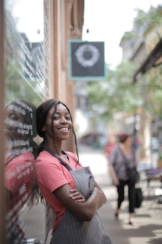 Shallow Focus Photo of Woman Smiling While Leaning on Glass Wall